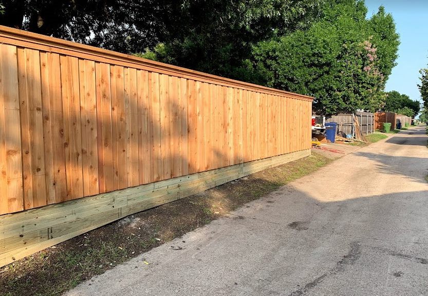 Stained wood fence on a stone base