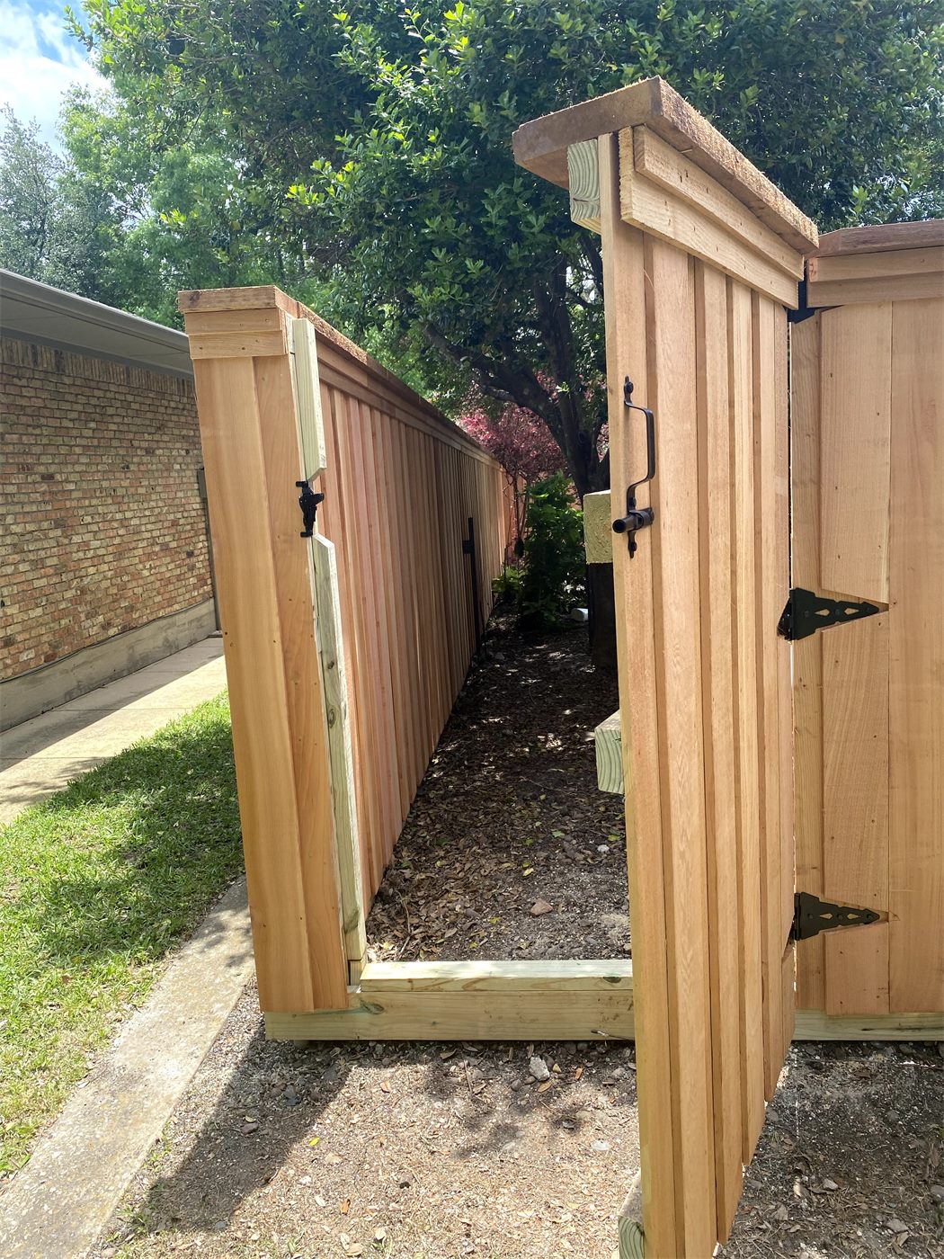 Cedar fence with a matching gate and black hinges